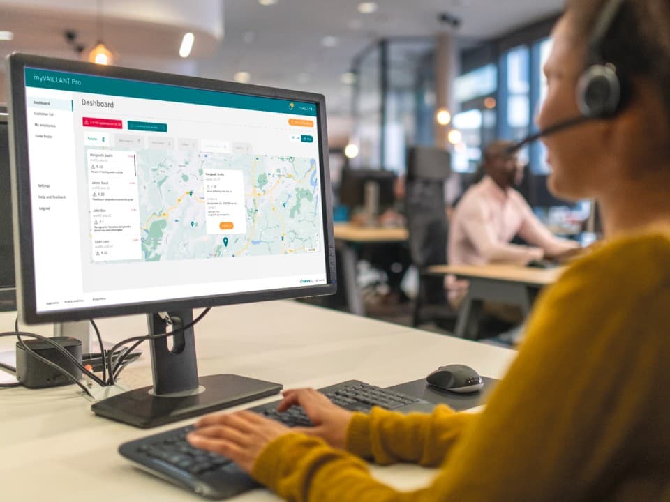 Frau mit Headset am Schreibtisch